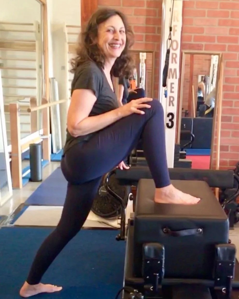 Carol practising Pilates on studio equipment